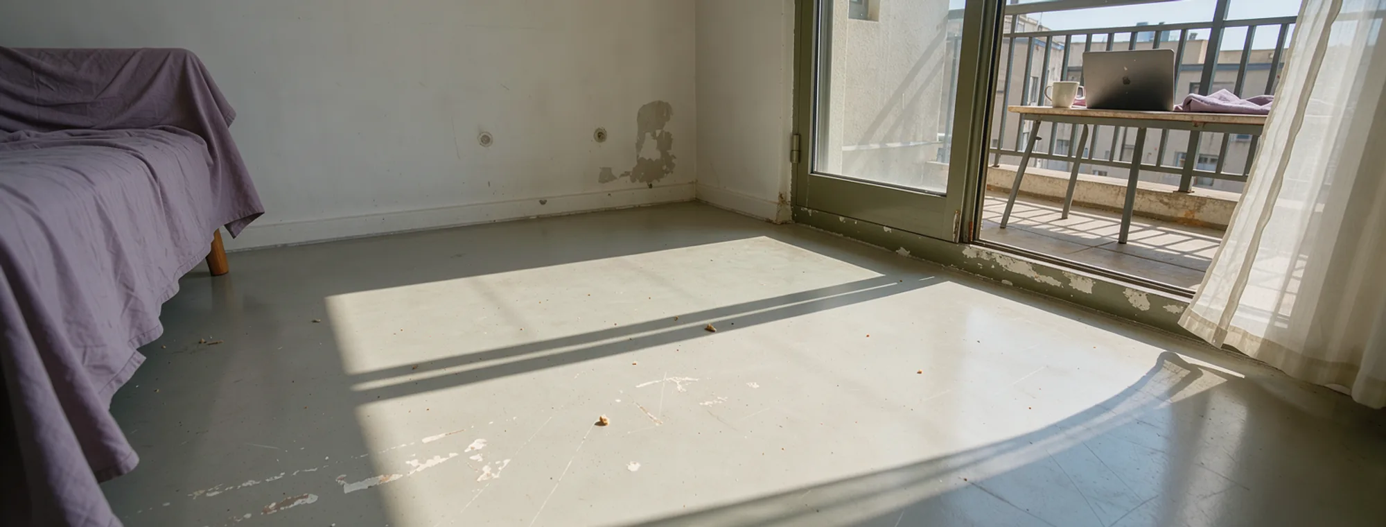 Two unequal rectangles of balcony-door light cross an empty apartment floor.